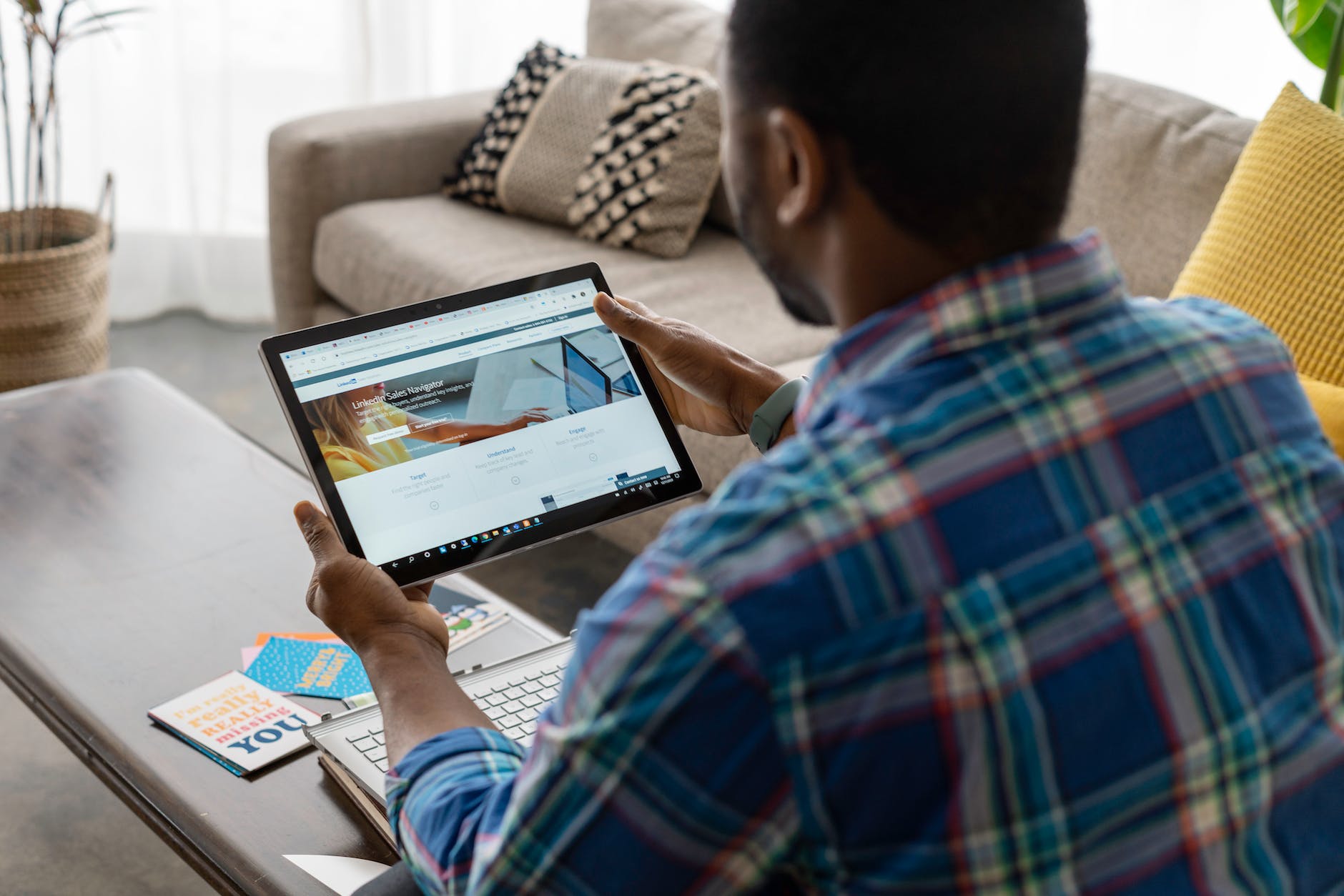 a person in blue plaid long sleeves holding a tablet